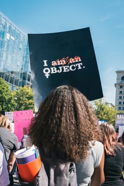 person i demonstrationståg med skylt där det står "I am an object", men "am an" är överstruket.