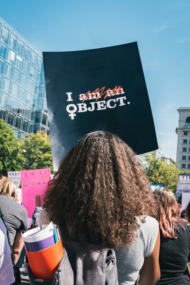person i demonstrationståg med skylt där det står "I am an object", men "am an" är överstruket.